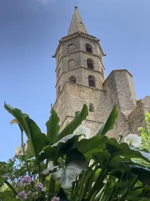 an old church with a tower with flowers in the foreground at Les Ordalies in Castelnaudary