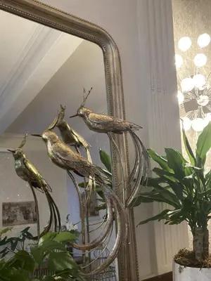 a mirror with a statue of a bird on it at Les Ordalies in Castelnaudary