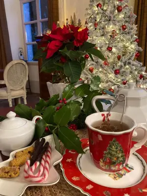 a christmas table with a cup of coffee and a christmas tree at Les Ordalies in Castelnaudary