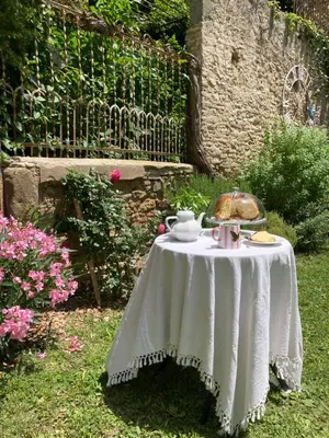 a table in a garden with a white table cloth at Les Ordalies in Castelnaudary