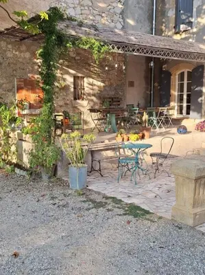 a patio with a bench and a table and chairs at domaine de Capoulade in Narbonne