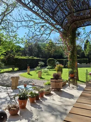 a patio with potted plants and a pergola at domaine de Capoulade in Narbonne