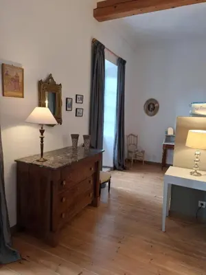 a room with a dresser and a lamp on a wooden floor at domaine de Capoulade in Narbonne