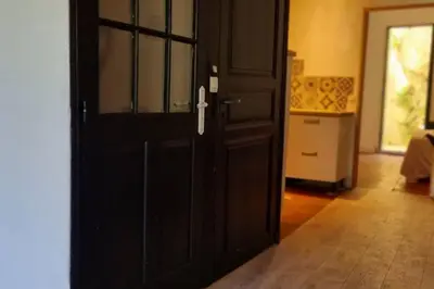 a black door in a room with a kitchen at Gîte de la confluence in Padern