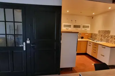 a kitchen with a black door leading into a kitchen at Gîte de la confluence in Padern