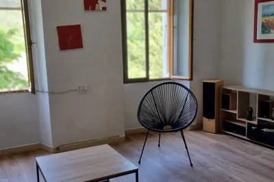 a living room with a chair and a table at Gîte de la confluence in Padern