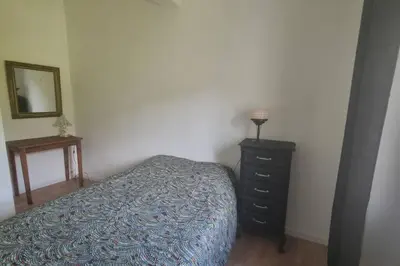 a bedroom with a bed and a dresser and a mirror at Gîte de la confluence in Padern