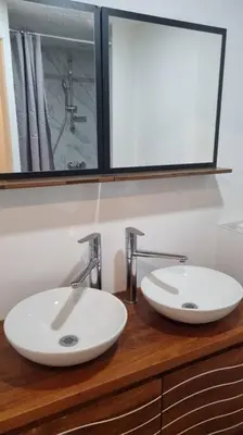 two sinks on a wooden counter in a bathroom at Gîte de la confluence in Padern