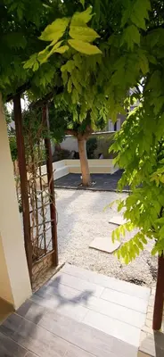 an open door to a courtyard with trees at Maison Magnolia in Marcorignan