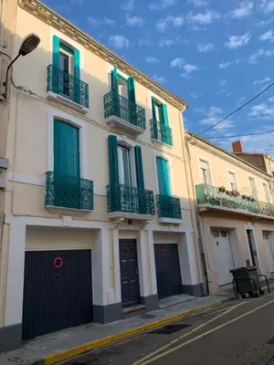 a building with green shutters and balconies on a street at Appartement Les Halles 2, Climatisation, Terrasse, Garage in Narbonne