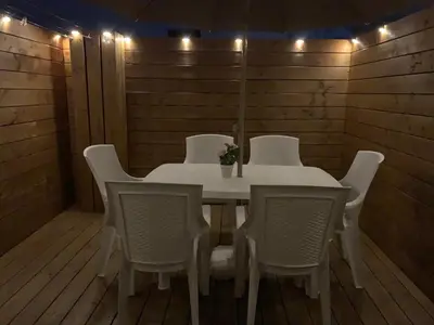 a white table and chairs in a room with lights at Appartement Les Halles 2, Climatisation, Terrasse, Garage in Narbonne