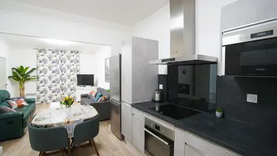 a kitchen with a table and a living room at Appartement Les Halles 2, Climatisation, Terrasse, Garage in Narbonne