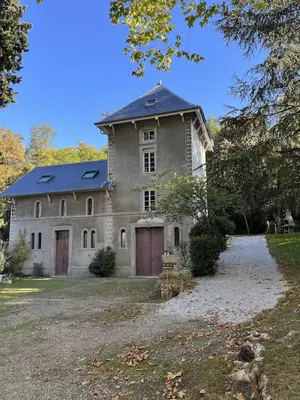 a large stone house with a blue roof at la Tour du Grand DUC in Cenne-Monestiès