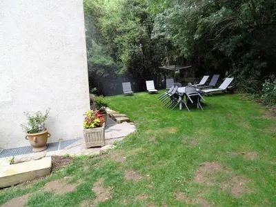 a patio with a table and chairs in a yard at la Tour du Grand DUC in Cenne-Monestiès