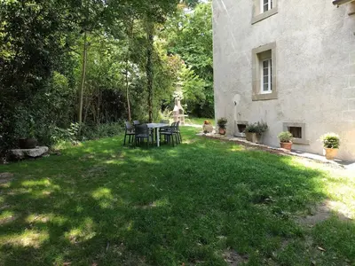 a yard with a table and chairs in front of a building at la Tour du Grand DUC in Cenne-Monestiès