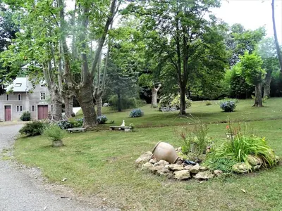 a yard with a house and a garden with trees at la Tour du Grand DUC in Cenne-Monestiès