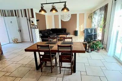 a living room with a wooden table and chairs at Villa 140 m² hab. avec piscine in Castres