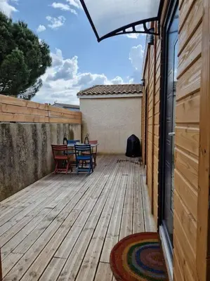 a patio with a table and chairs on a wooden deck at studio des lices Villesequelande in Villesequelande