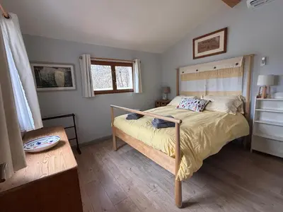 a bedroom with a large bed with a wooden headboard at Lodge with private pool surrounded by vineyards in Azille