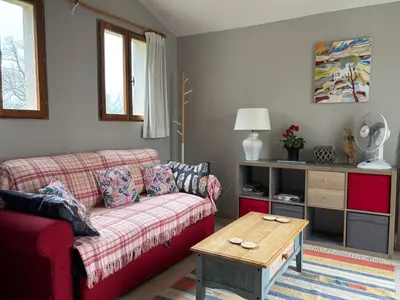 a living room with a red couch and a table at Lodge with private pool surrounded by vineyards in Azille