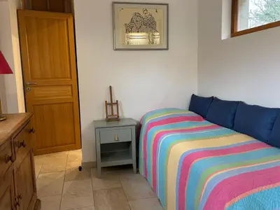 a bedroom with a bed with a colorful striped blanket at Lodge with private pool surrounded by vineyards in Azille