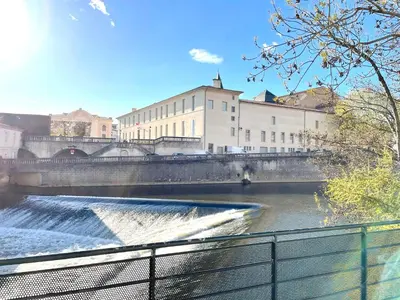 a river with a bridge and waterfalls at L'intemporel - Grand T2 Confort en Hypercentre in Castres
