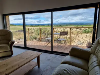 a living room with a couch and a view of a deck at Domaine Ô Lingot d'Oc in Roubia