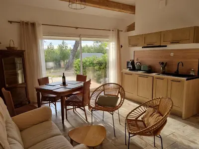 a living room with a table and chairs and a kitchen at Domaine Ô Lingot d'Oc in Roubia
