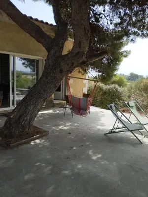two chairs sitting under a tree next to a house at Domaine Ô Lingot d'Oc in Roubia