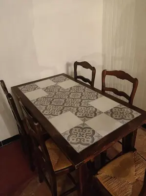 a wooden table with two chairs and a table with a tablecloth at VILLA VILATA A PADERN DANS LES CORBIÈRES SAUVAGES in Padern