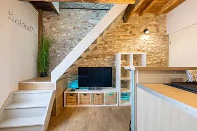 a living room with a tv under the stairs at L'alouette - Studio Duplex Confort en Hypercentre in Castres
