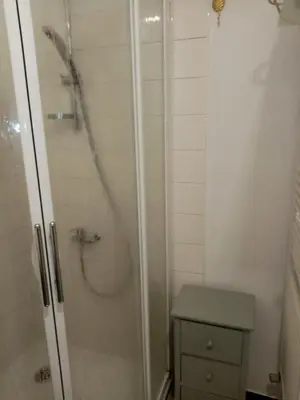 a bathroom with a shower with a glass door at Les Toiles du Figuier in Espéraza