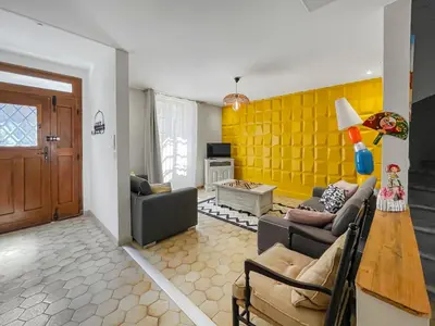 a living room with a couch and a yellow wall at Superbe Villa avec piscine, 4 chambres à Vinassan in Vinassan