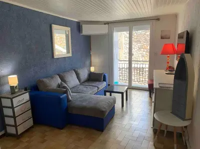 a living room with a blue couch and a tv at Le colibri in Lapalme
