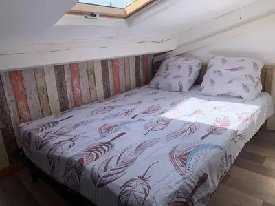 a bed with a blanket and pillows on it at Le colibri in Lapalme