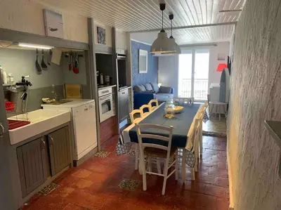 a kitchen and dining room with a table and chairs at Le colibri in Lapalme