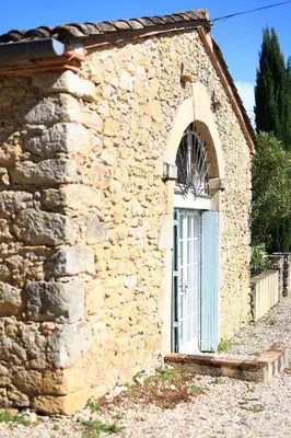 a stone building with a door and a window at Gites de Labadie in Lautrec