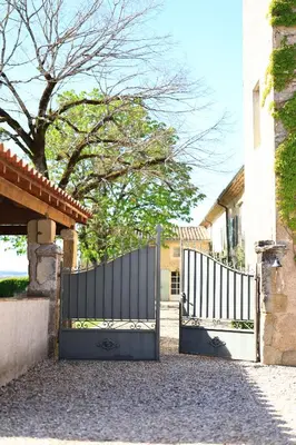 a pair of gates in front of a house at Gites de Labadie in Lautrec