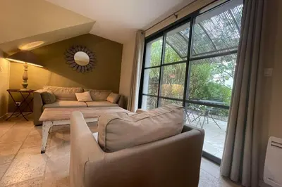 a living room with a couch and a large window at Maison au cœur des Corbières in Saint-Laurent-de-la-Cabrerisse