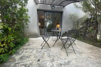 a patio with a table and chairs in front of a house at Maison au cœur des Corbières in Saint-Laurent-de-la-Cabrerisse