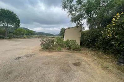 an empty parking lot with flowers and a building at Maison au cœur des Corbières in Saint-Laurent-de-la-Cabrerisse