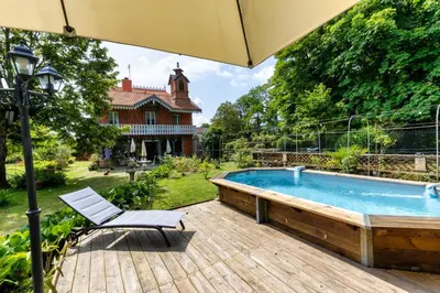 a patio with a pool and a chair and an umbrella at Domaine La Belle Histoire - Gîte côté Parc in Besset