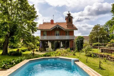 an old house with a swimming pool in front of a house at Domaine La Belle Histoire - Gîte côté Parc in Besset