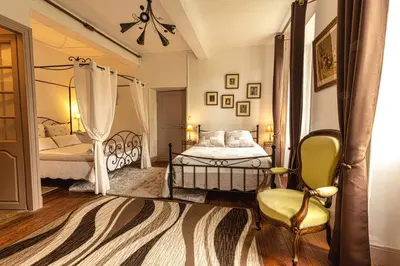 a bedroom with two beds and a chair at Domaine La Belle Histoire - Gîte côté jardin in Besset