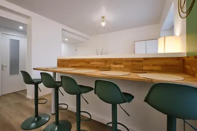 a kitchen with a counter with green stools at Magnifique T3 centre ville avec WIFI RDC in Limoux