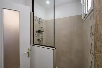 a shower with a glass door in a bathroom at Magnifique T3 centre ville avec WIFI RDC in Limoux