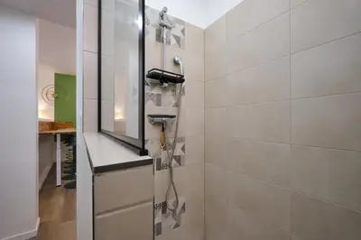 a bathroom with a shower with a mirror at Magnifique T3 centre ville avec WIFI RDC in Limoux