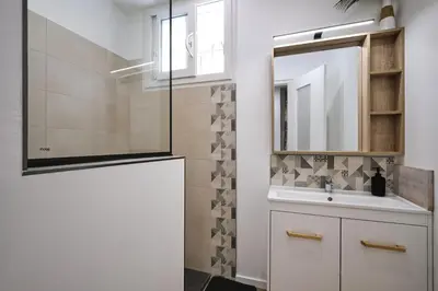 a bathroom with a sink and a mirror at Magnifique T3 centre ville avec WIFI RDC in Limoux