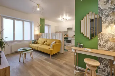 a living room with a yellow couch and a kitchen at Magnifique T3 centre ville avec WIFI RDC in Limoux
