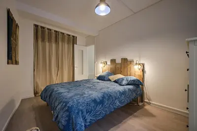 a bedroom with a bed with a blue comforter at Magnifique T3 centre ville avec WIFI RDC in Limoux
